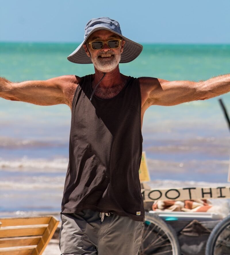 A happy man welcomes you to the beach.
